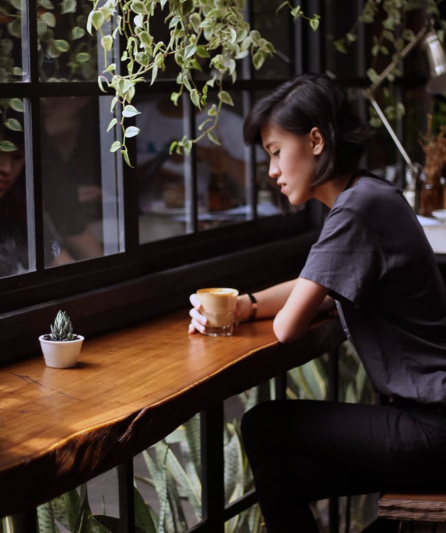 Mujer que piensa profundamente en una cafetería